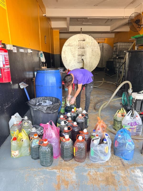 Bonet kereta penuh dengan tong dan botol minyak masak terpakai di tepi jalan