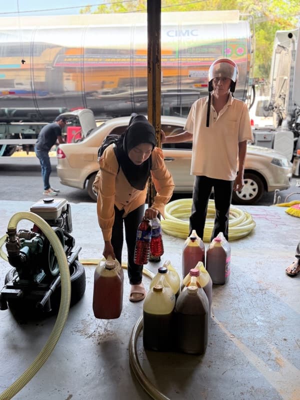 Pekerja MSR mengepam minyak masak terpakai dari tong ke lori