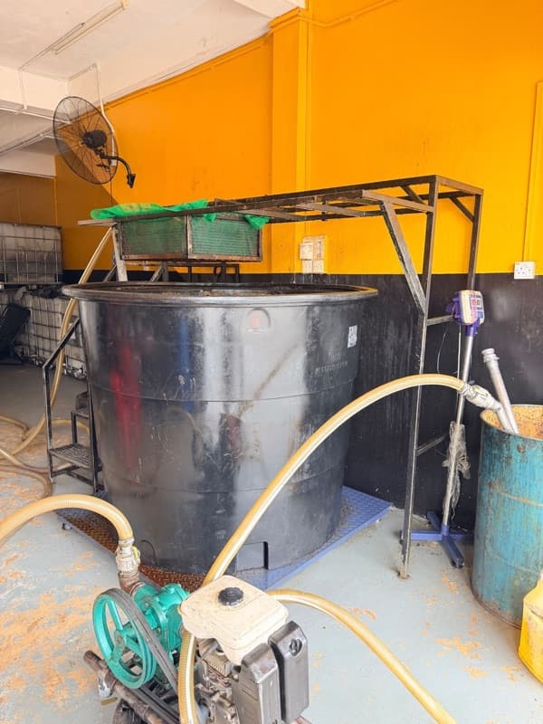 Botol dan tong minyak masak terpakai disusun di hadapan kedai gudang