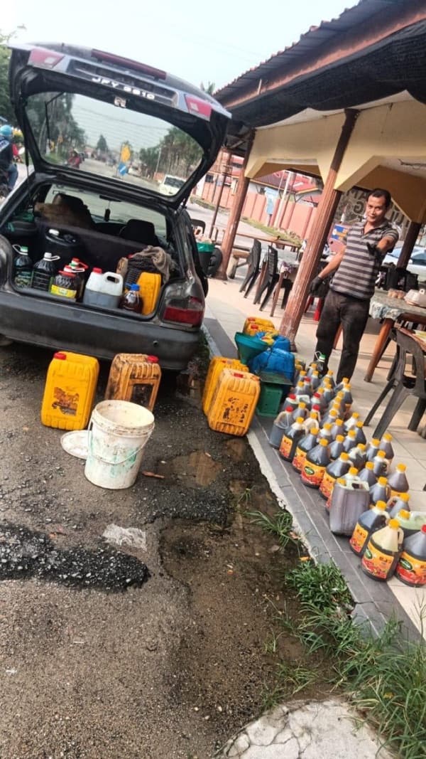 Staf MSR membuka tutup botol minyak masak terpakai yang dihantar pelanggan