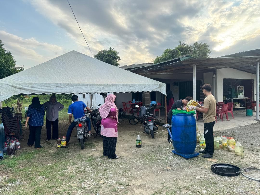 Pelanggan dan staf MSR menimbang minyak masak terpakai di bawah khemah di tapak kutipan