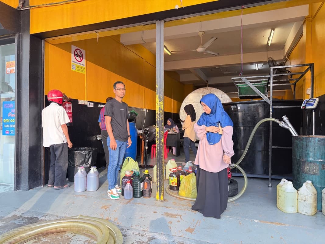 Pelanggan membawa botol minyak masak terpakai ke gudang MSR untuk ditimbang